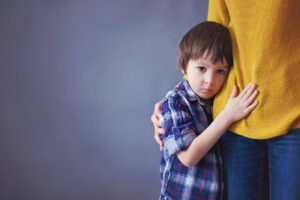 Sad little child, boy, hugging his mother at home