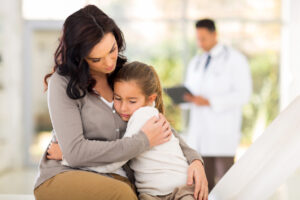 young woman and her sick daughter waiting in doctor's room