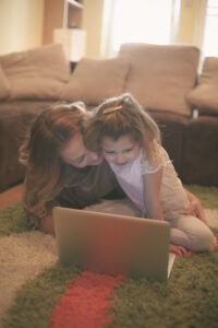 Mother and daughter reading on laptop.